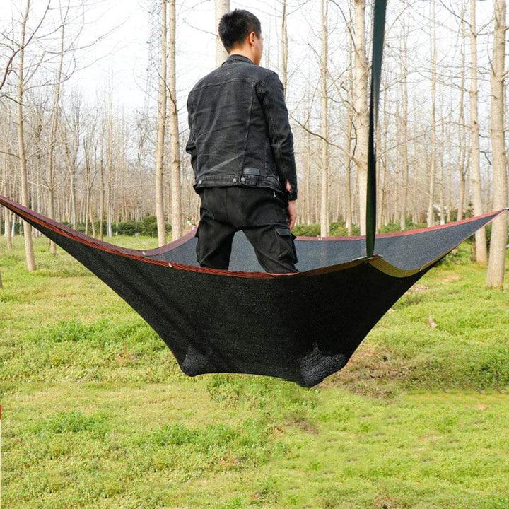 Fitlybuy black UV shade net suspended between trees, demonstrating durability and UV protection in a forest setting.
