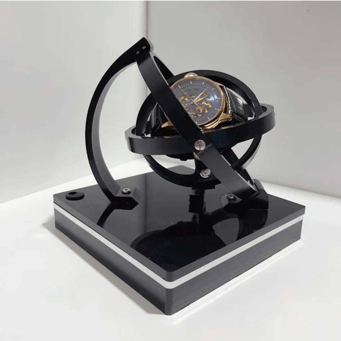 Fitlybuy luxury black automatic watch winder with a 360-degree rotating spherical design holding a skeleton watch.