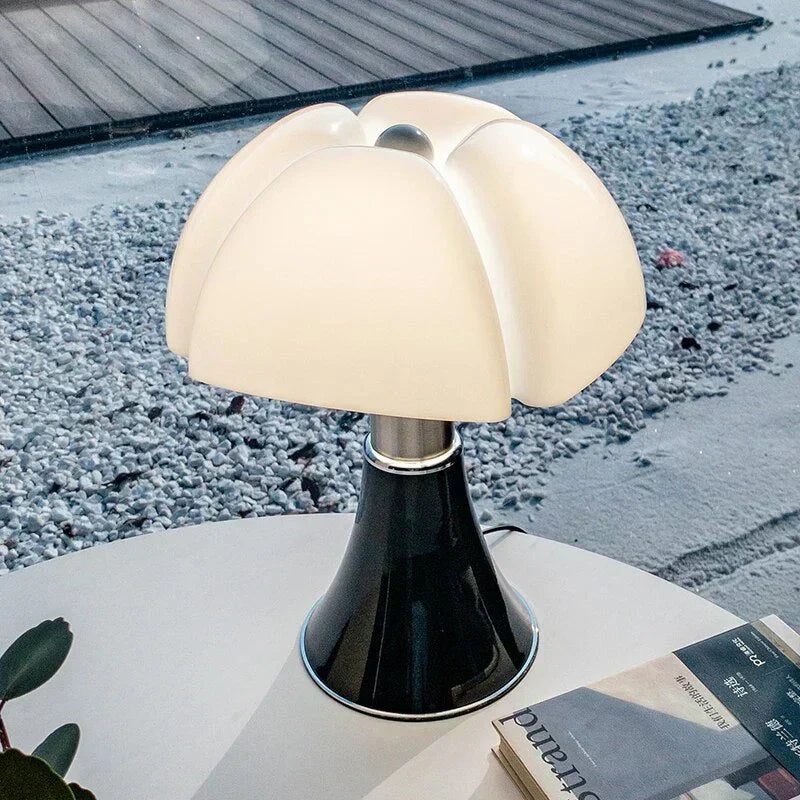 Fitlybuy FloraLuxe floral table lamp with glowing white petals and a sleek black conical base on an outdoor table.